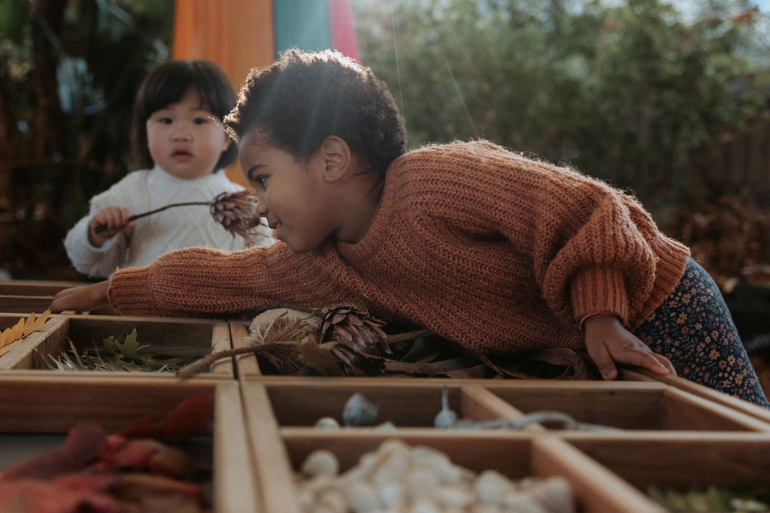  A Child Reaching Out to Grasp a Sensory Material on the Table