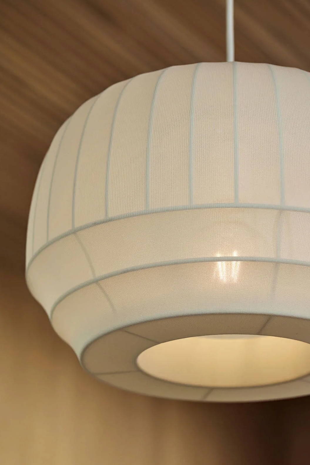 White pendant lamp hanging from a ceiling.