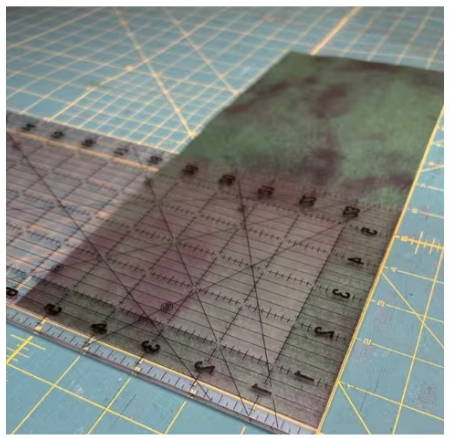 Take your green fabric and cut one 2.5-inch wide by 12-inch long fabric strip. 