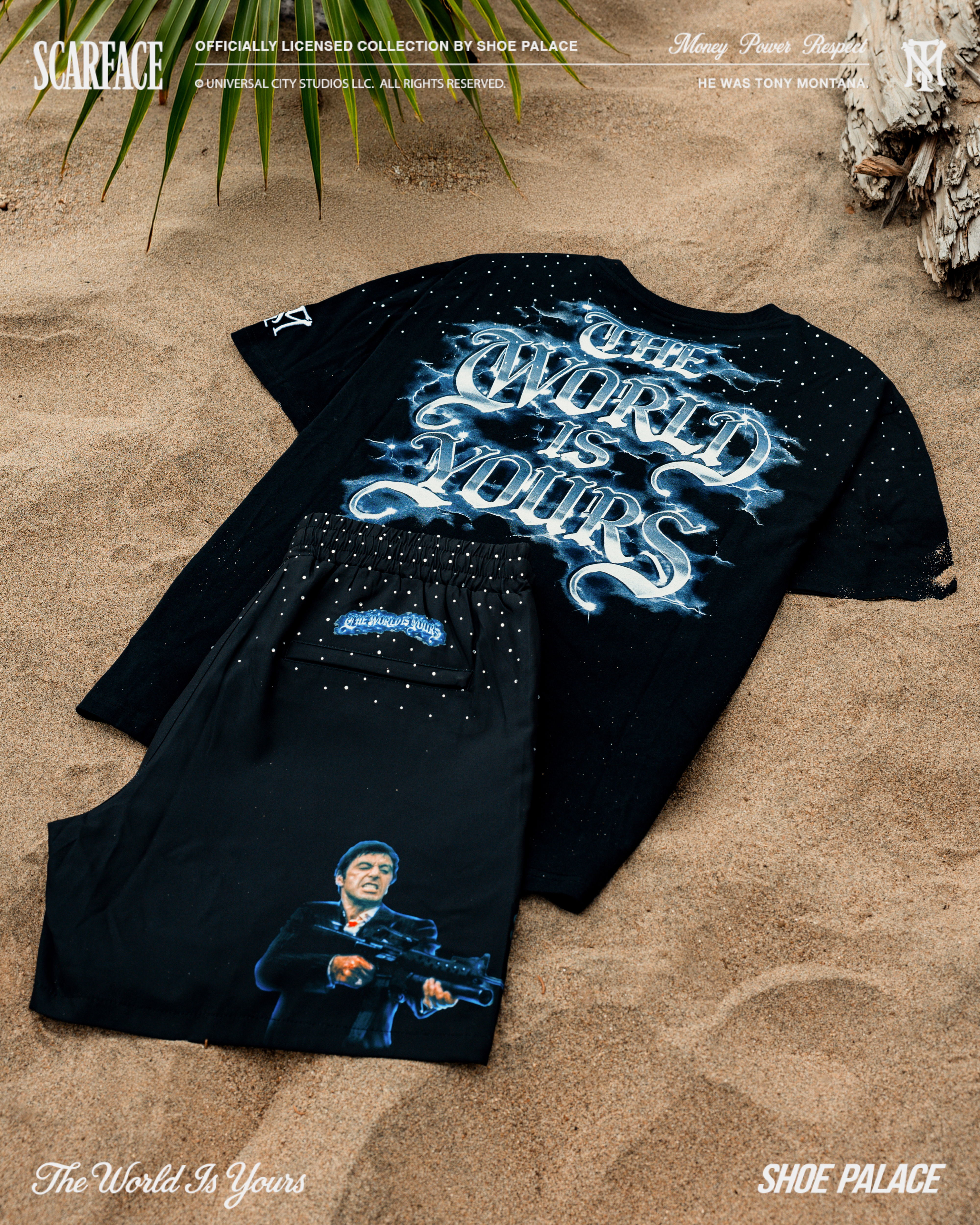Black t-shirt and shorts with graphic designs on sandy background.