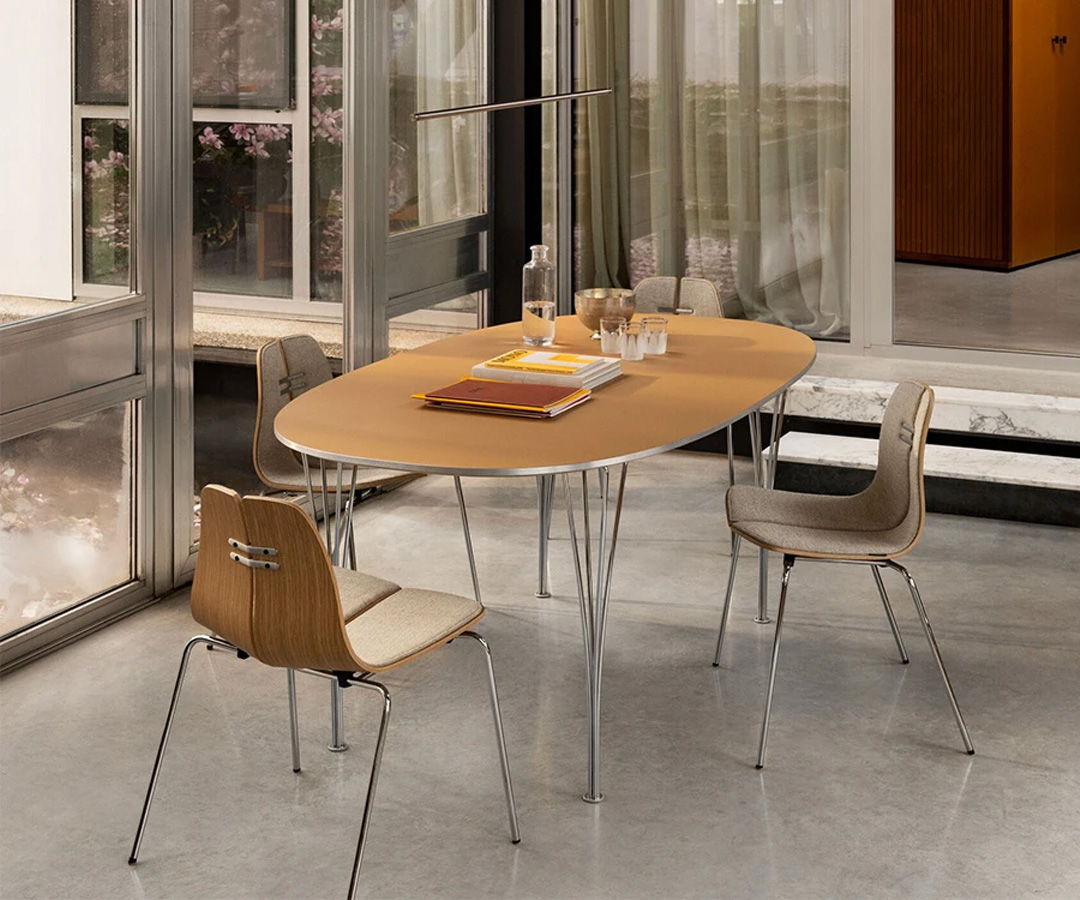 Modern Fritz Hansen dining area with an oval table and two chairs.