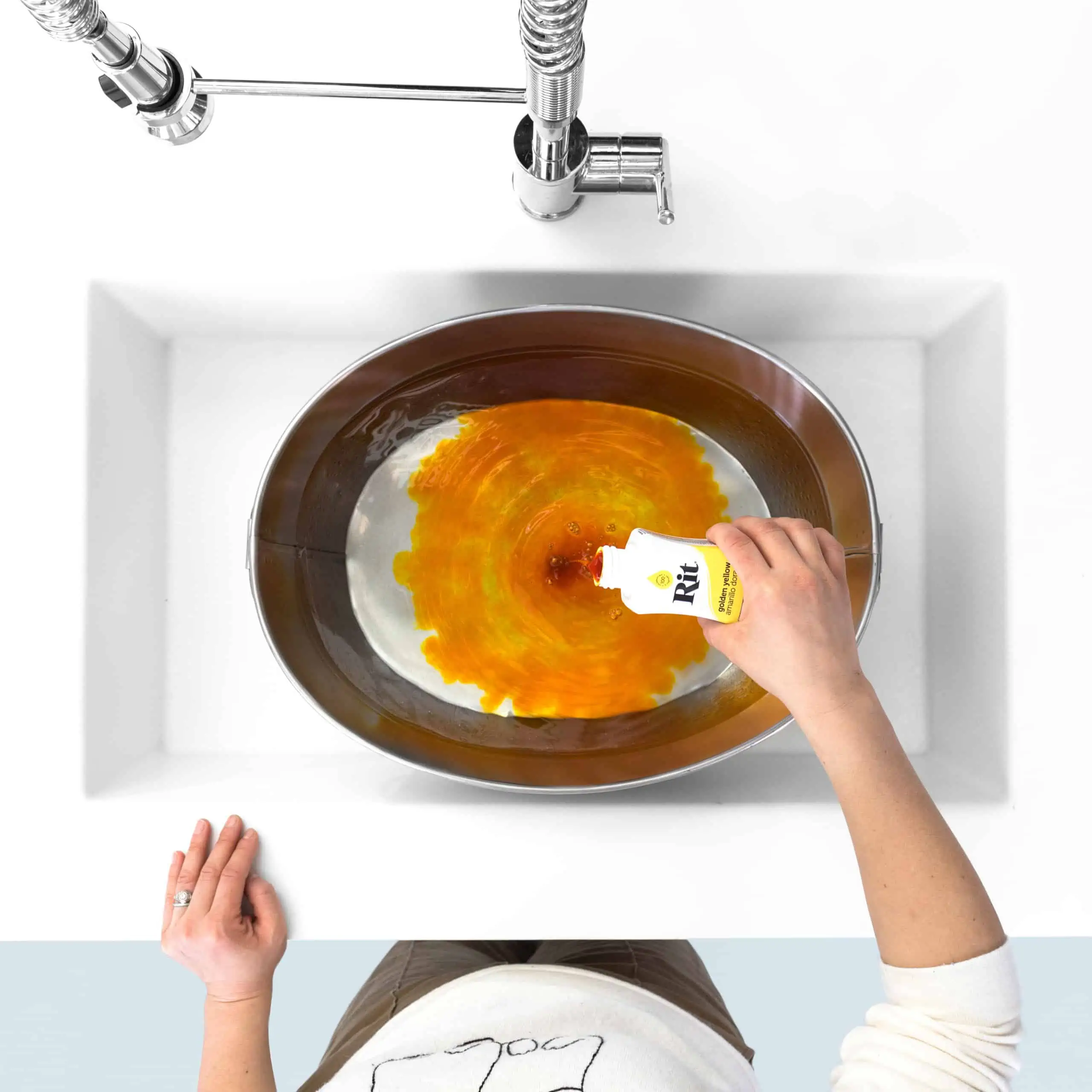 Person pouring liquid into a bowl with swirling orange contents.