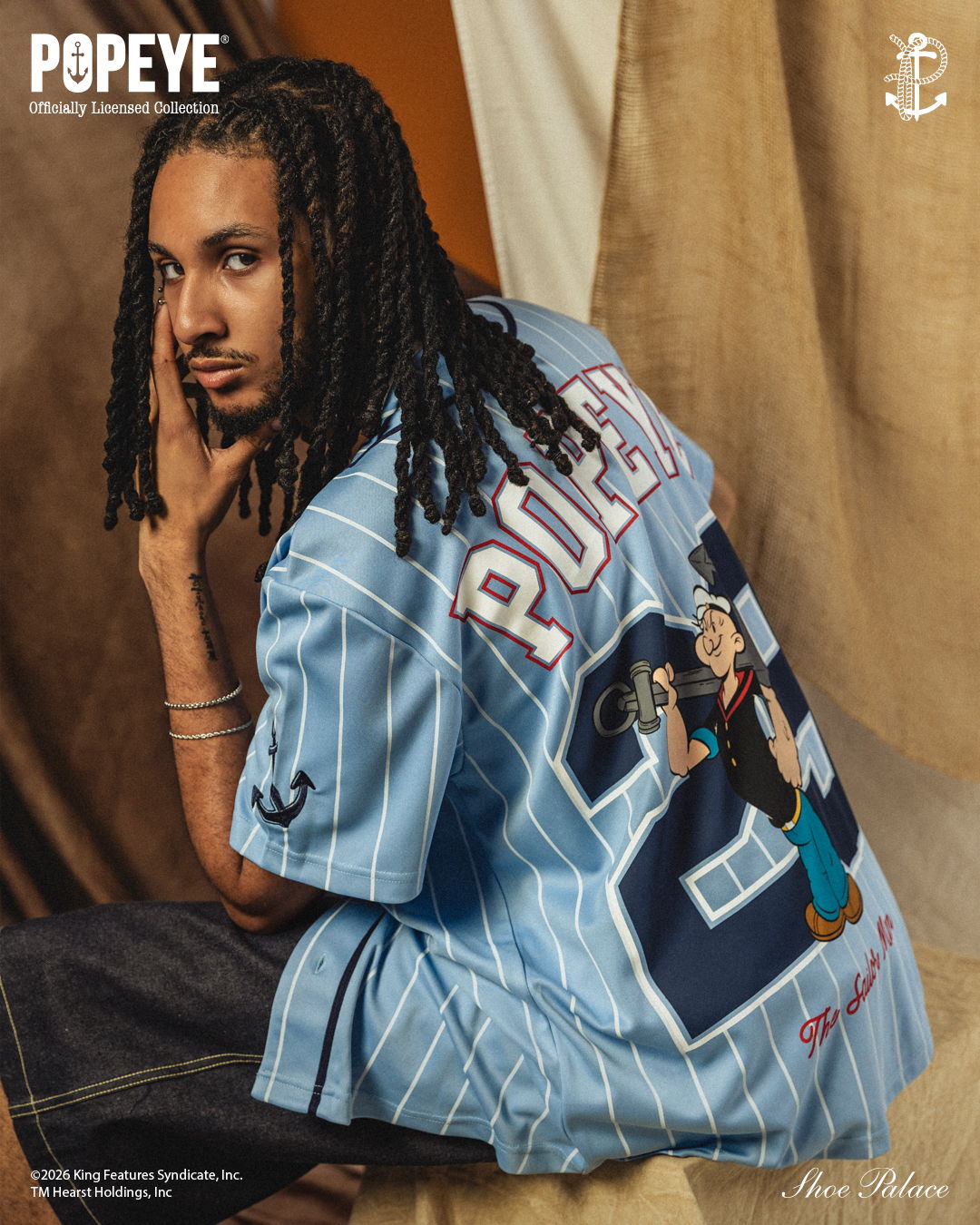 Person wearing a blue Popeye jersey, seated with a neutral background.