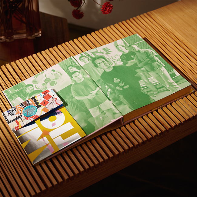 Open book on a wooden surface with colorful pages and a bookmark.