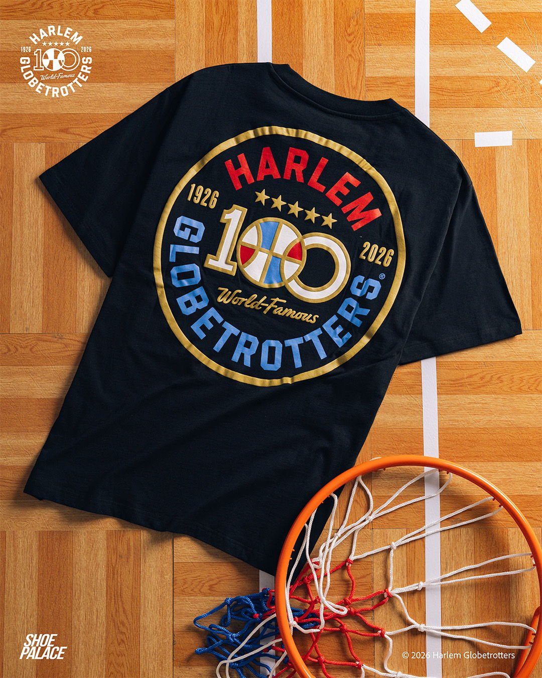 Black t-shirt featuring Harlem Globetrotters 100th anniversary logo on a wooden floor.