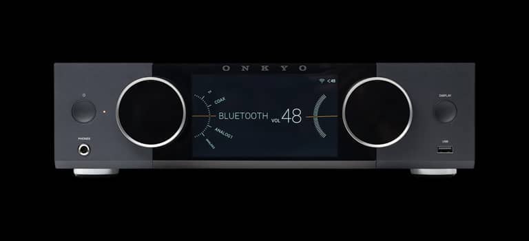 Modern audio receiver with digital display and control knobs.