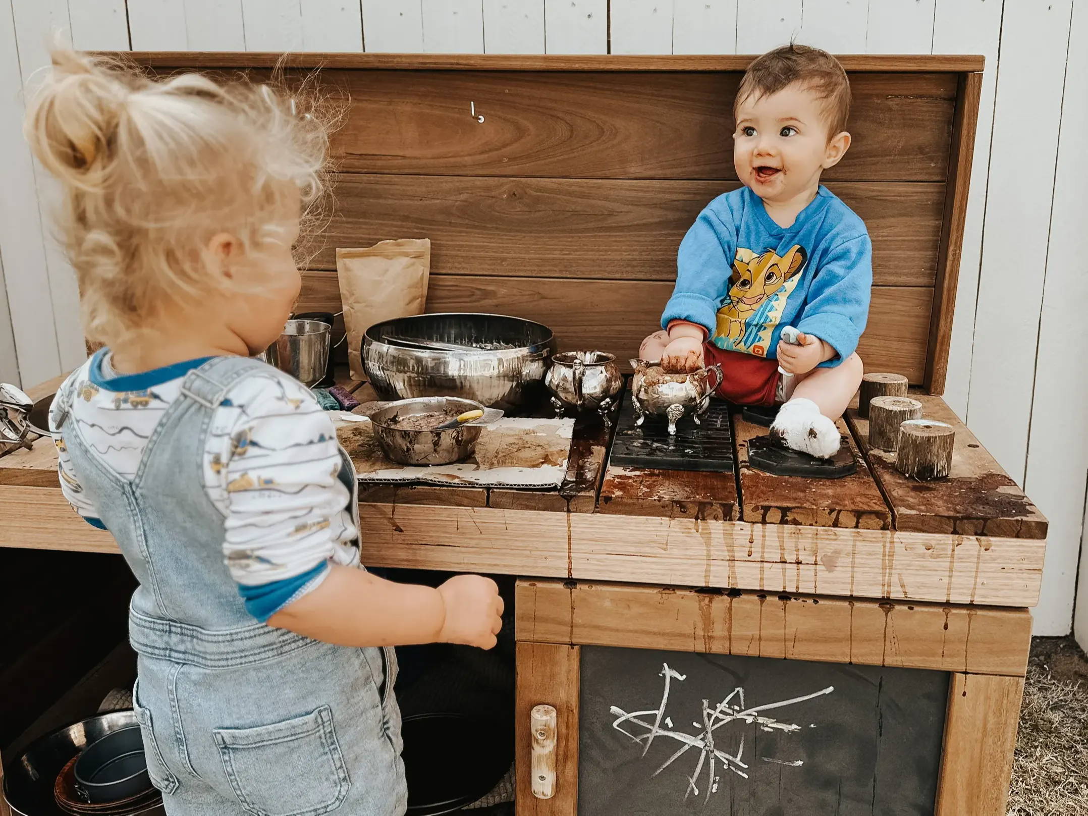 Kids enjoying a muddy play at a mud kitchen