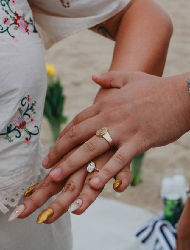 engaged couple holding hands with rings