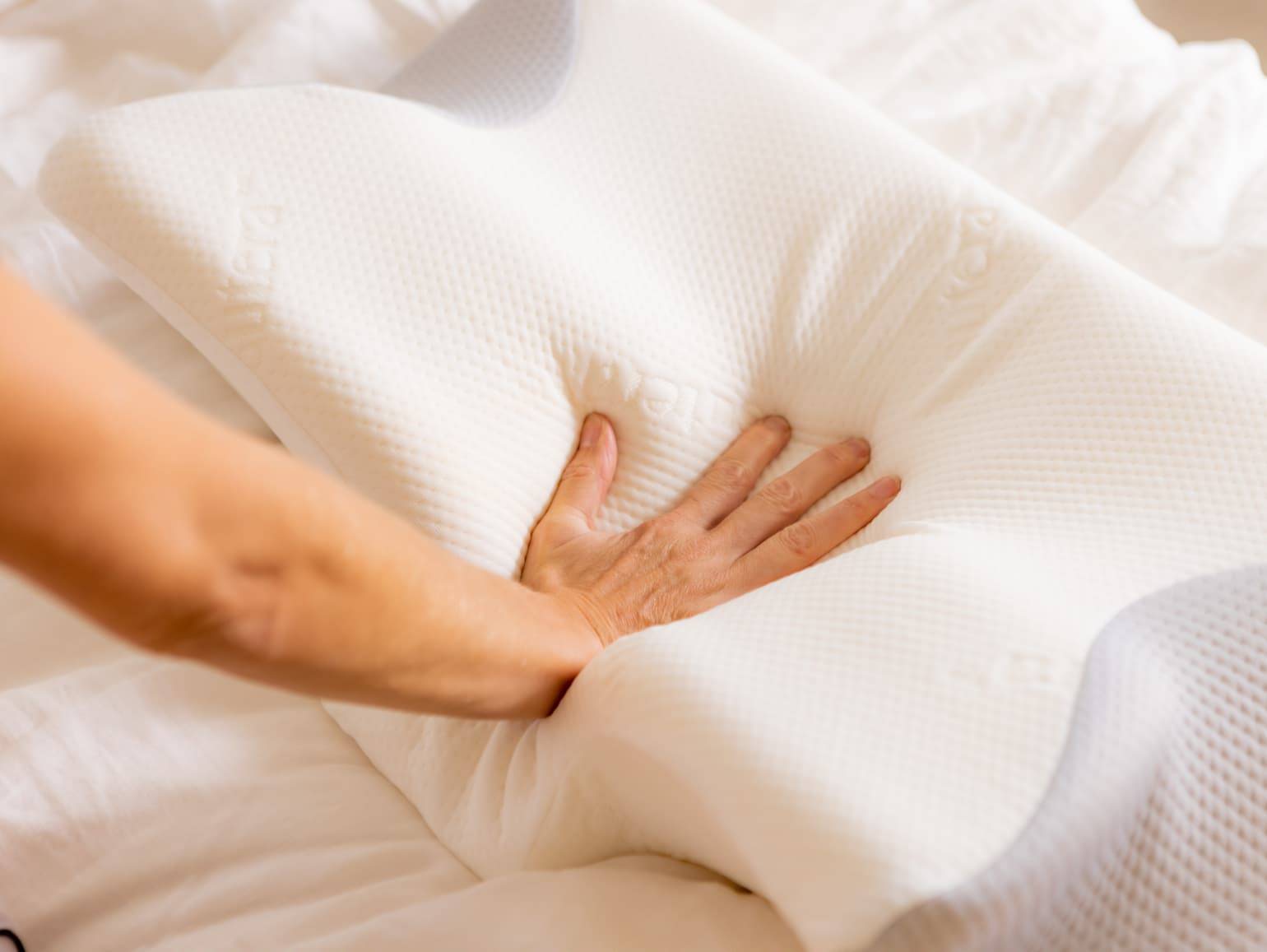 woman's hand demonstrating softness and memory aspect of pillow