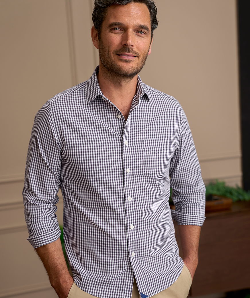 Man in a checkered shirt standing in a casual setting.