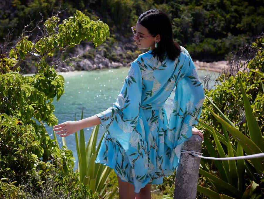 Woman wearing blue palm leaf printed cotton shirt over a matching one piece bathing suit by Ala von Auersperg and Cover Swim