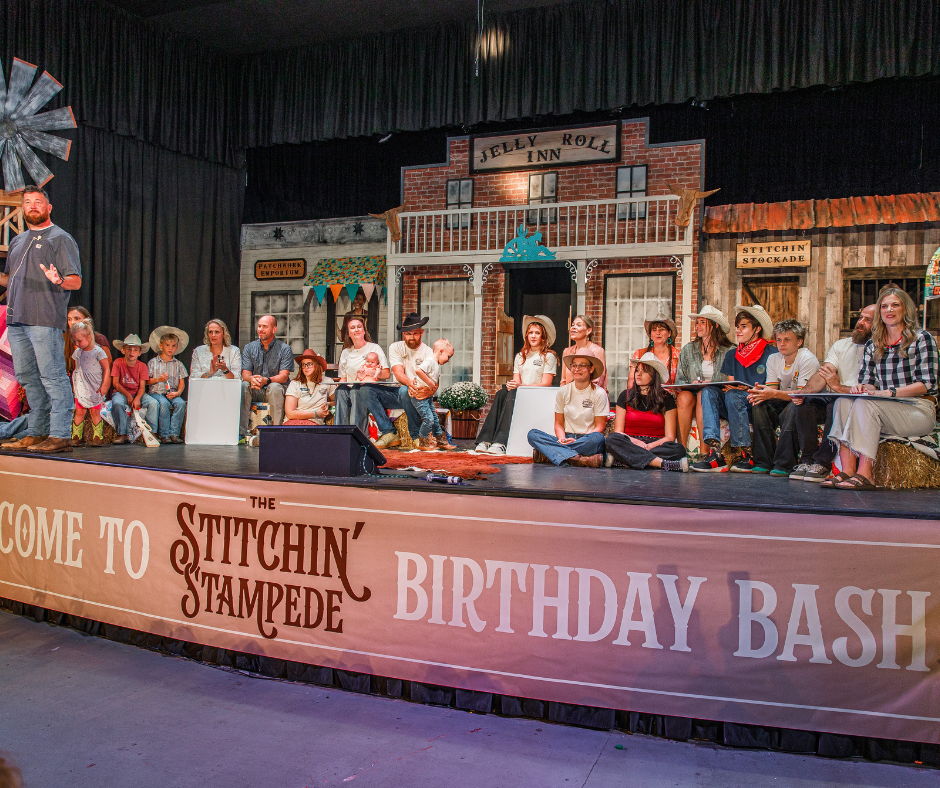 A stage with people seated for a birthday celebration event.