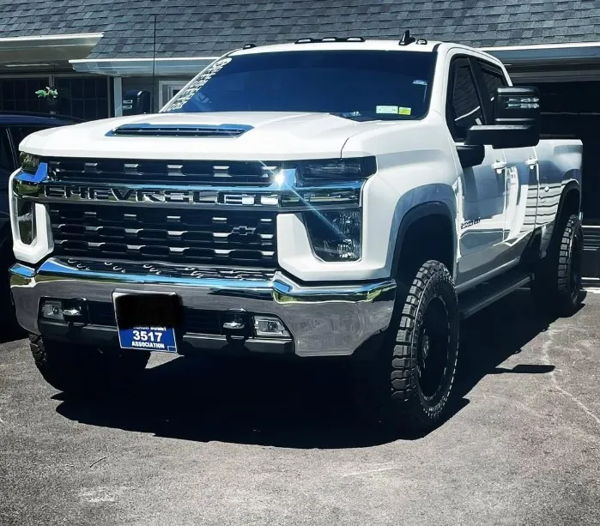 Front three-quarter view of David's white 2022 Chevy Silverado 2500HD parked in a driveway, Conductor's Special 844 Nightmare Edition install photo 1