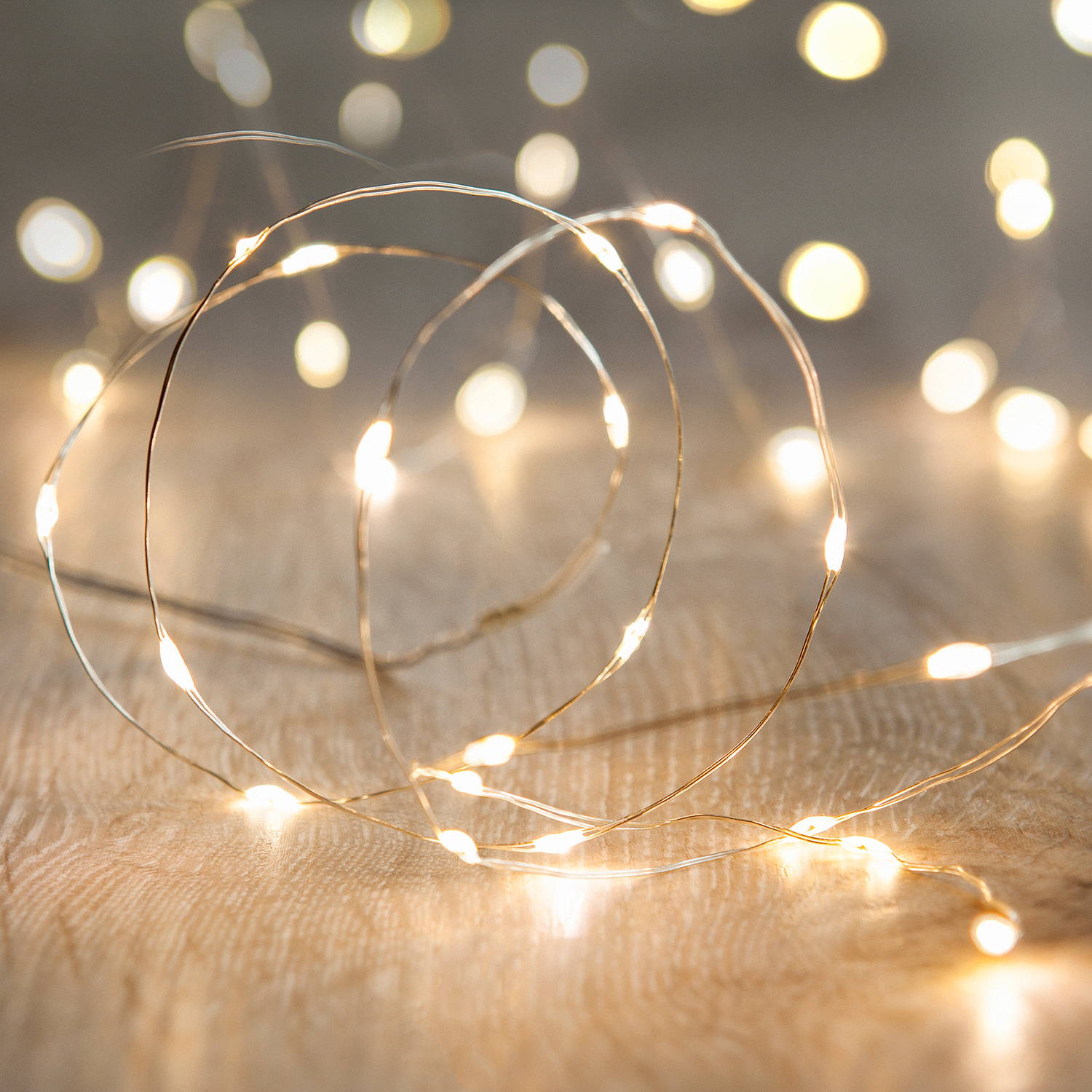 Warm white micro lights on a wooden floor in a spiral pattern.