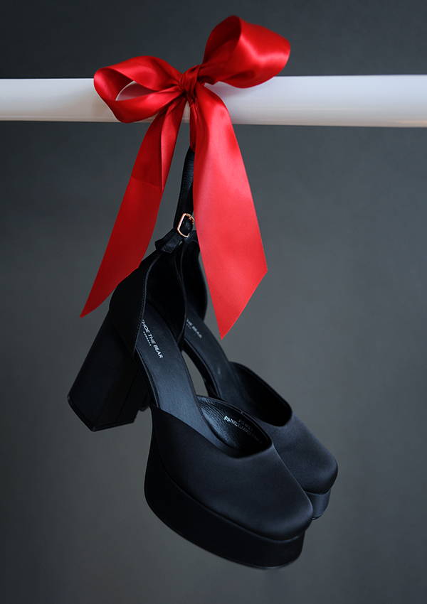 The Shoe the Bear Priscilla Ankle Strap shoes hanging on a rail with red ribbon.
