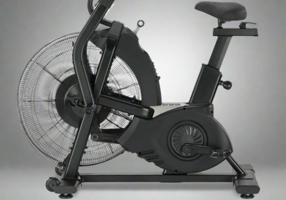 Black exercise bike with fan, side view, against a gray background.