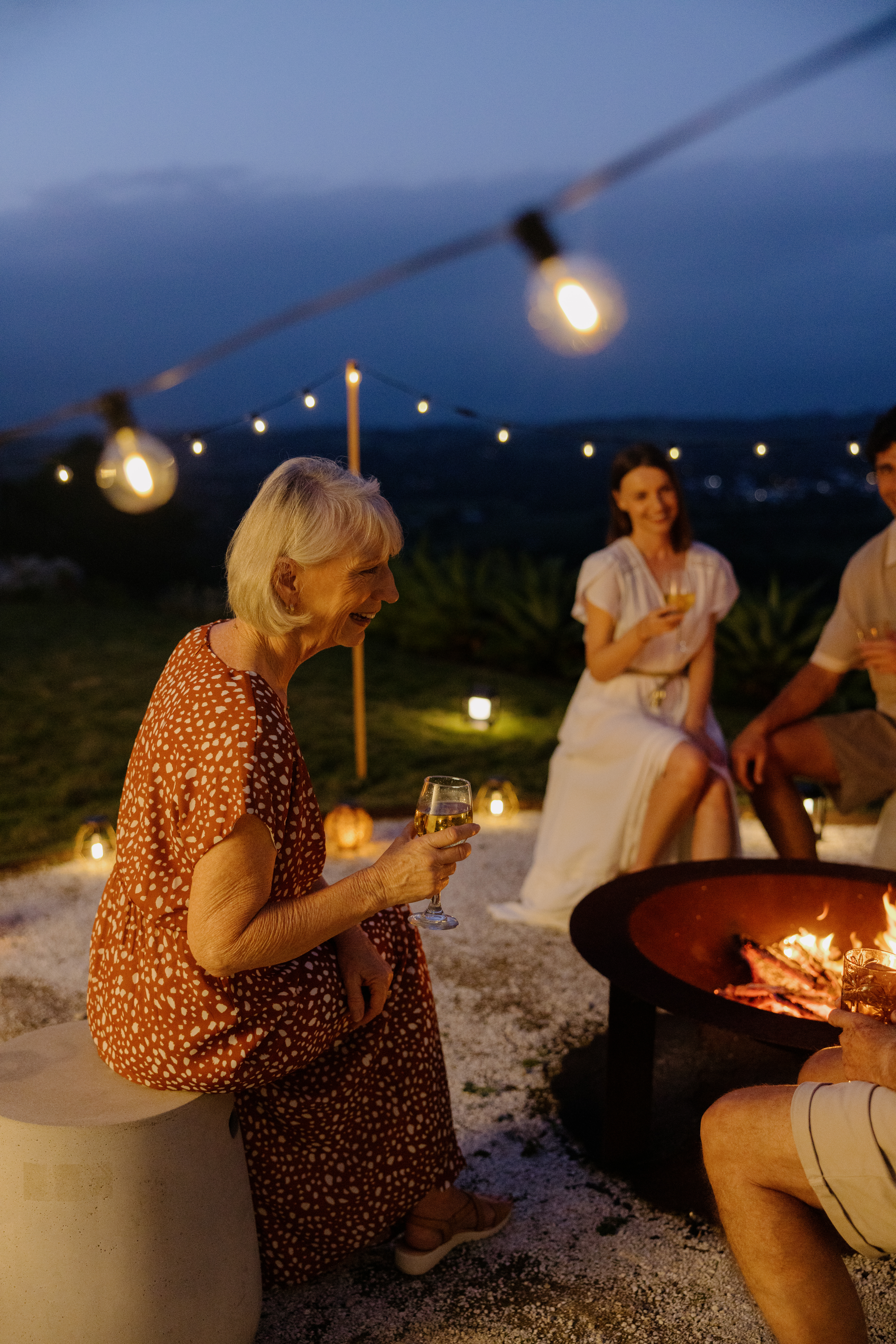 People enjoying a cozy fire pit gathering at dusk with Hoselink Solar Lights.