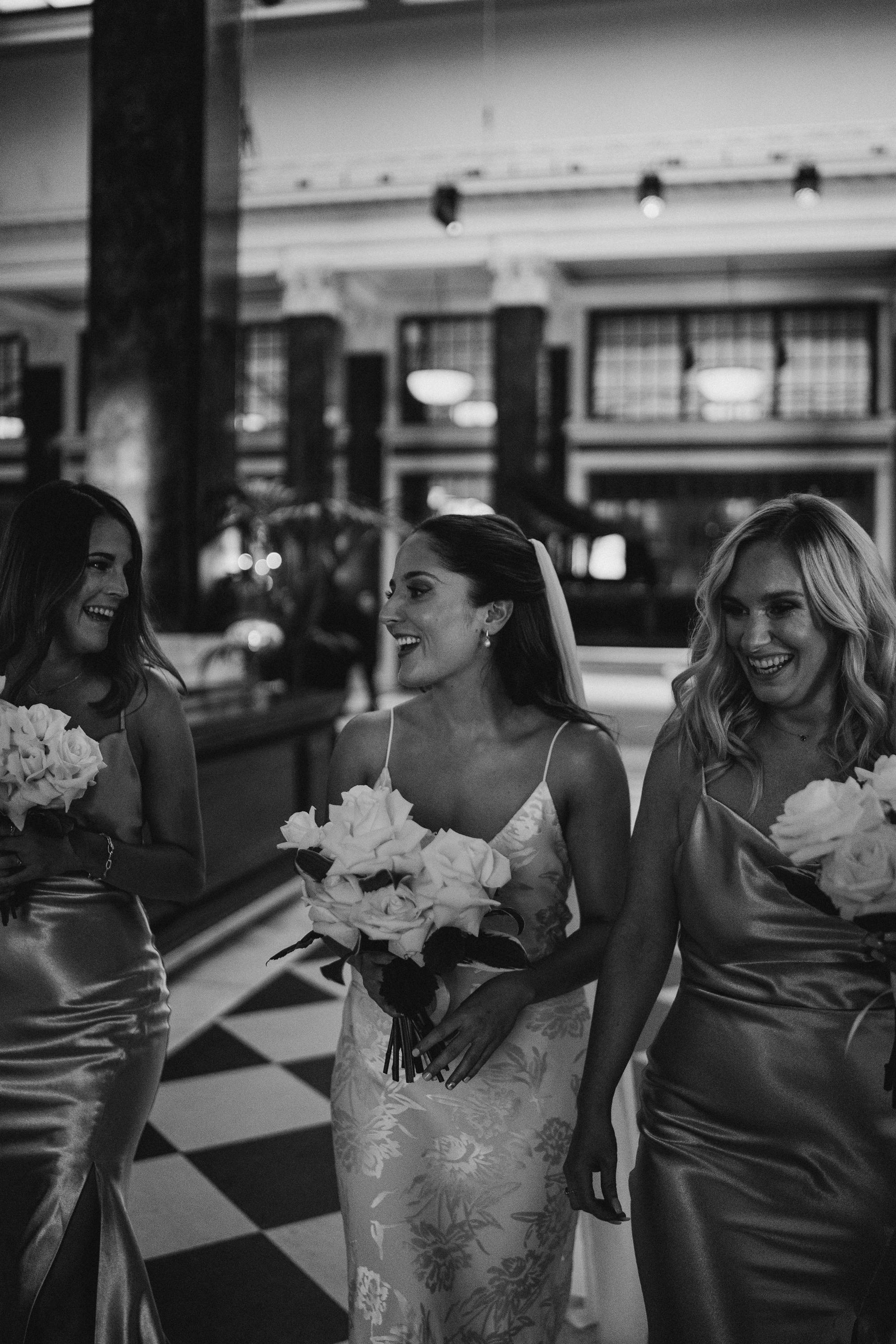 La mariée en dentelle rose marchant avec les demoiselles d'honneur.