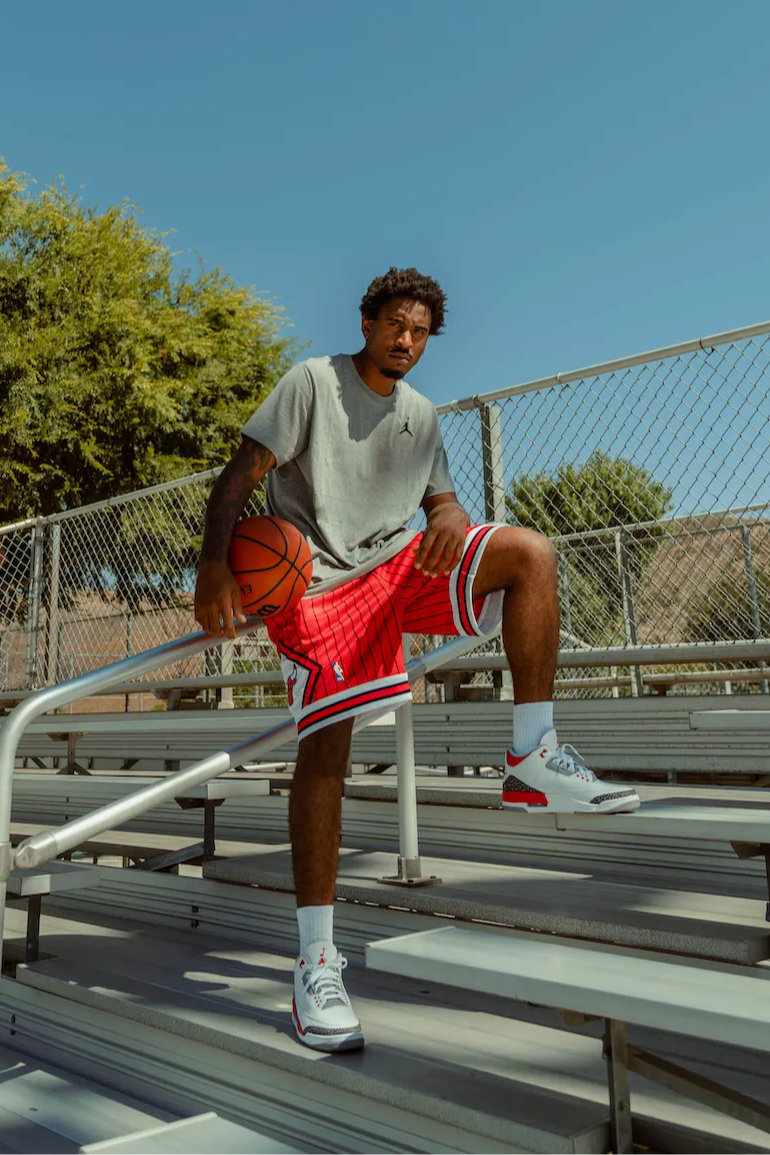 male model in aj3 retro og fire red standing on bleachers