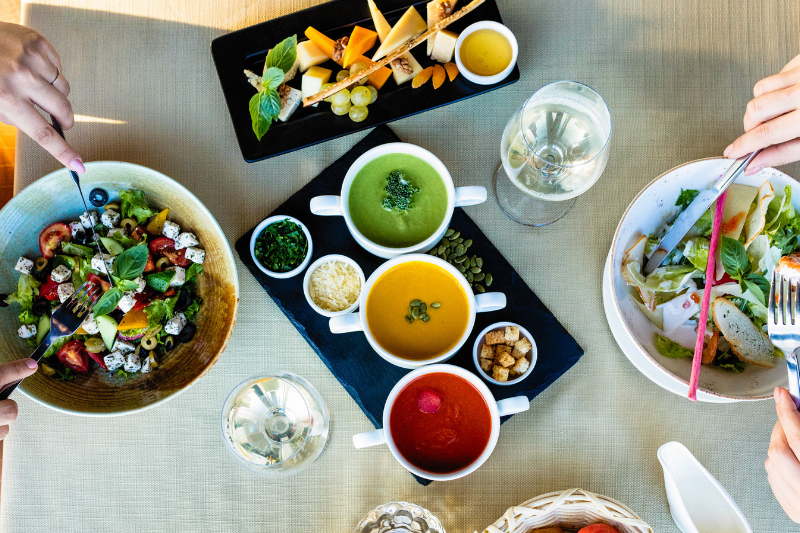 Two bowls of salad and colorful sauces on a table.