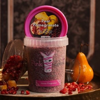 Container of pear pomegranate bath salts with fruit pieces on display.