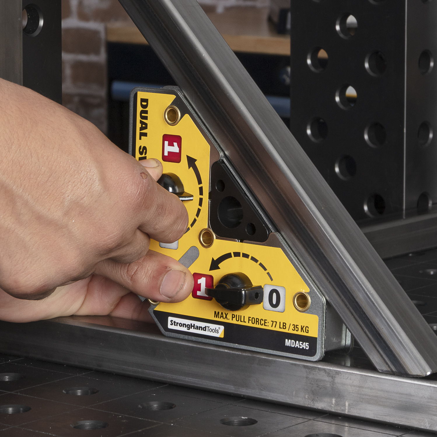 A hand adjusting a dual-axis angle gauge on a metal frame.