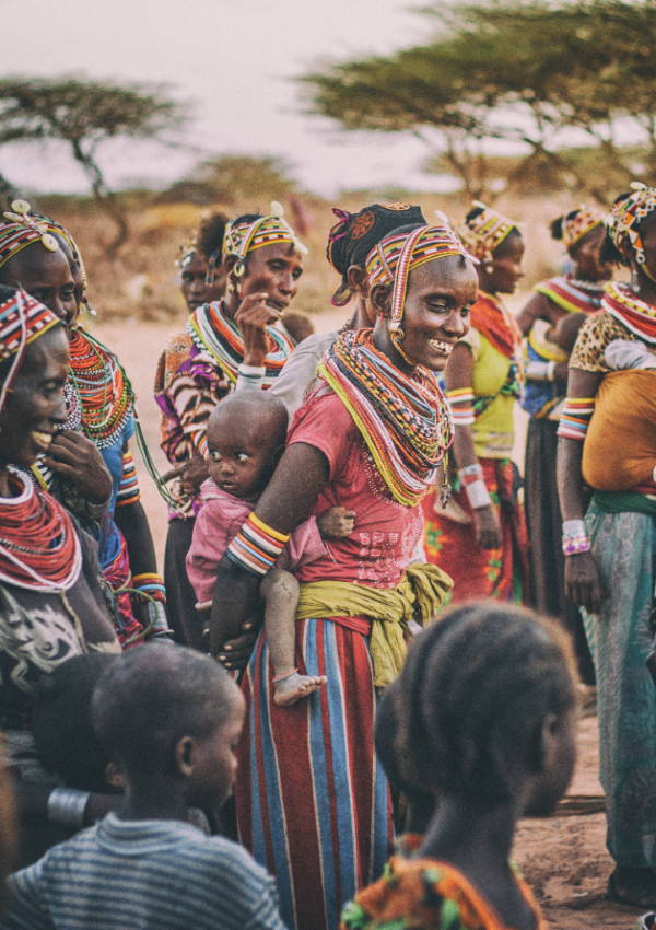 African traditional tribe wearing colorful clothing with baby on back