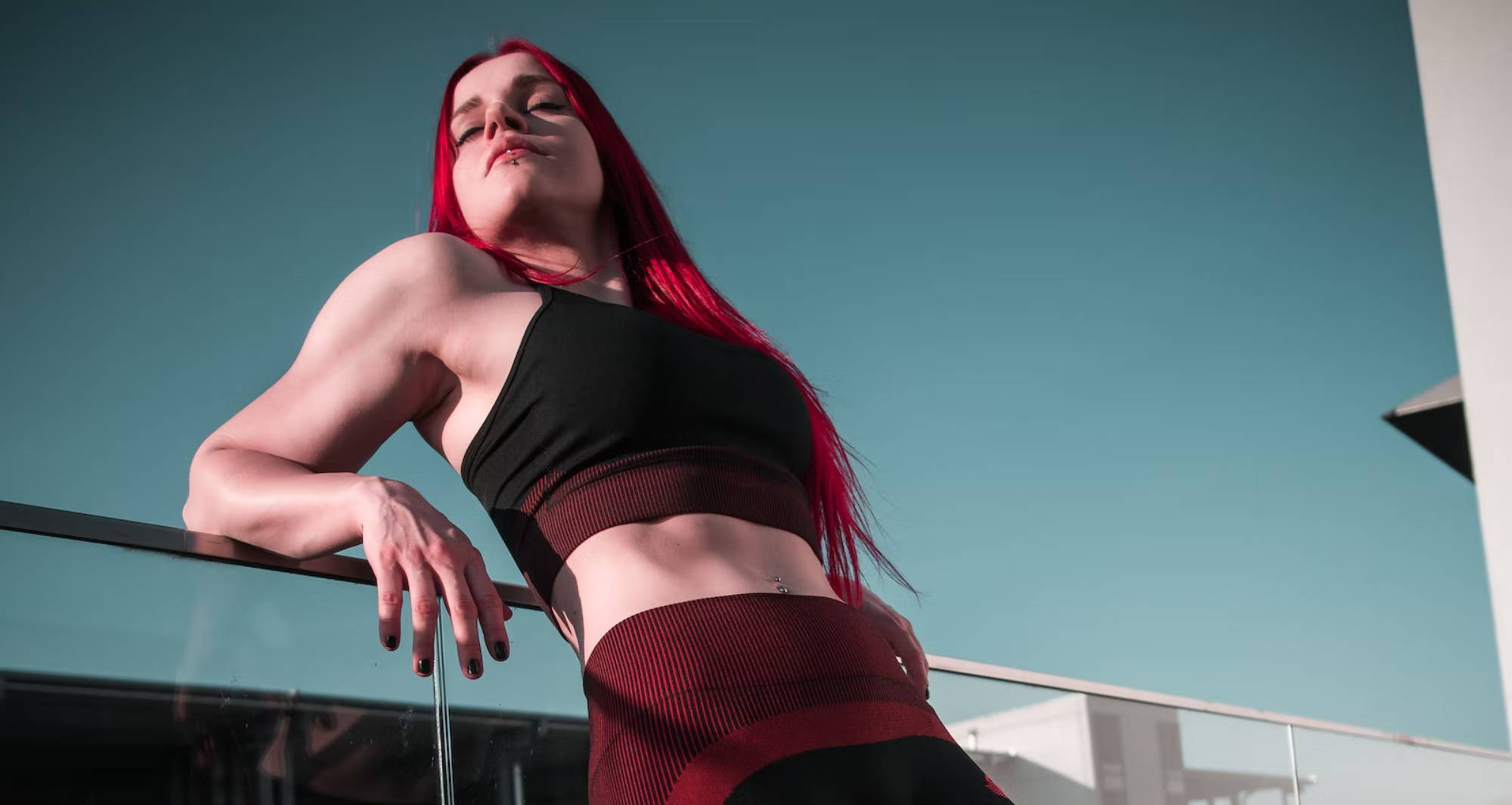 red haired woman wearing an all black and red spandex outfit