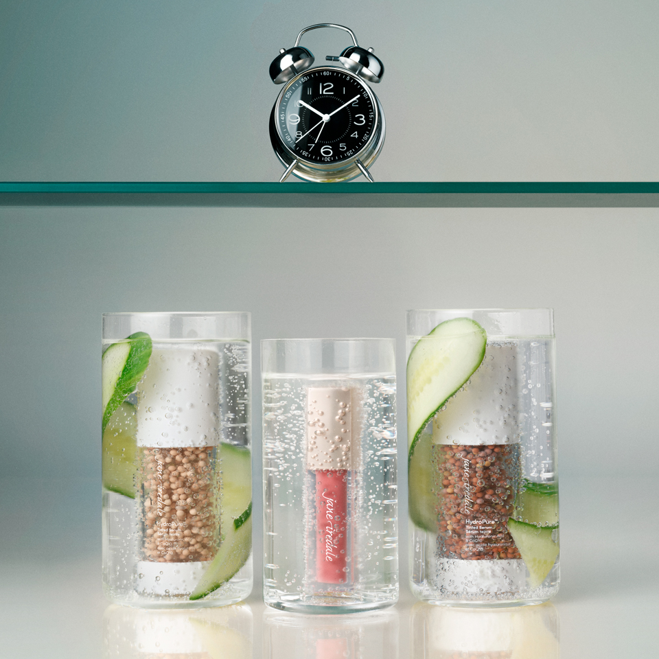 Three clear containers with ingredients and cucumber slices, alongside a clock.