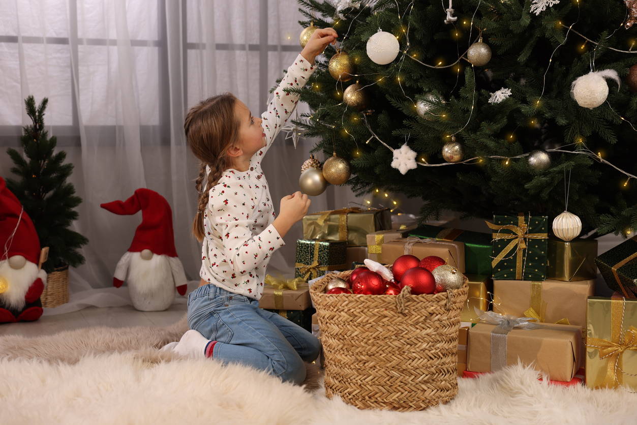 Little girl decorating Live Christmas Tree
