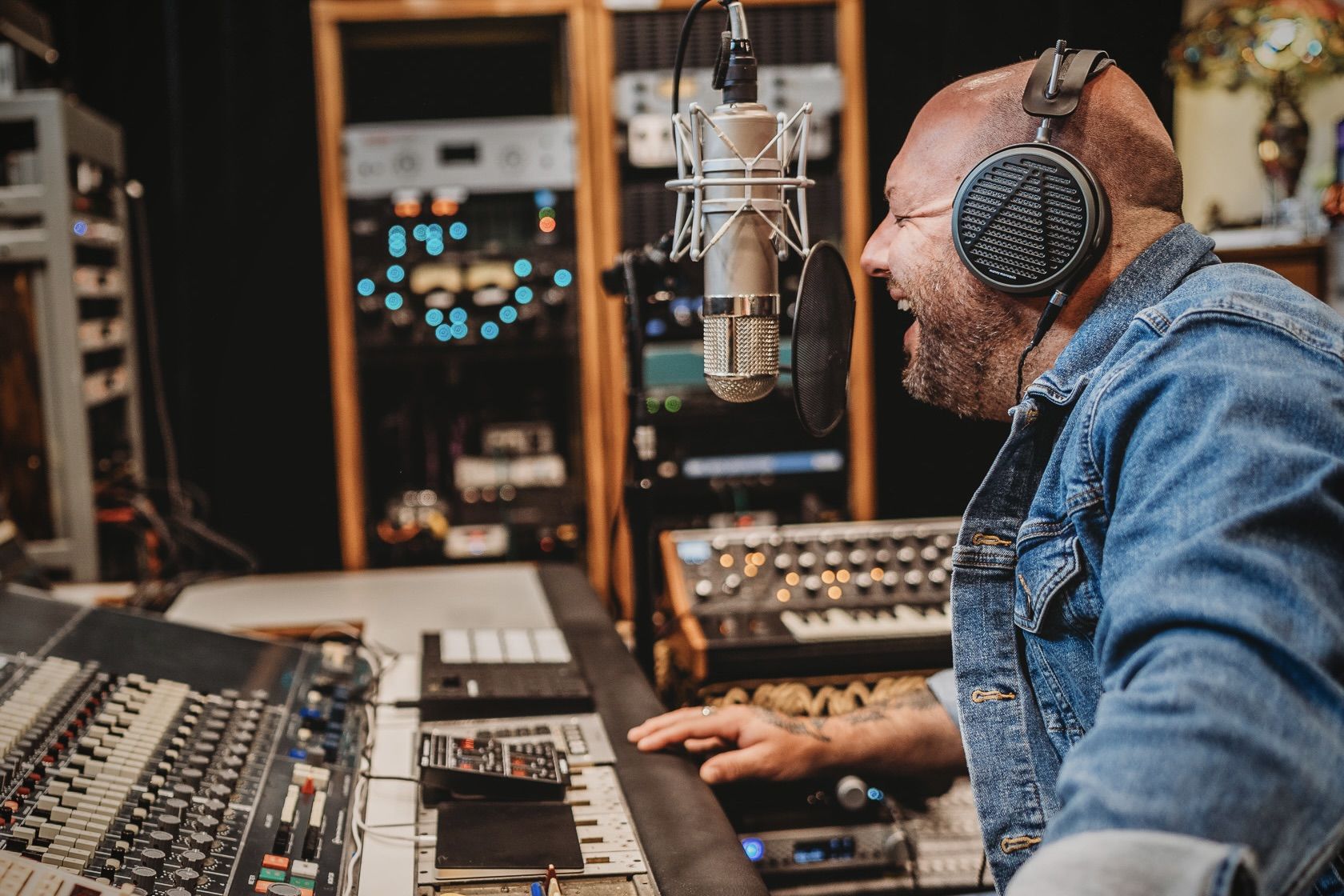Nick Jay wearing Audeze MM-500 headphone singing in the studio