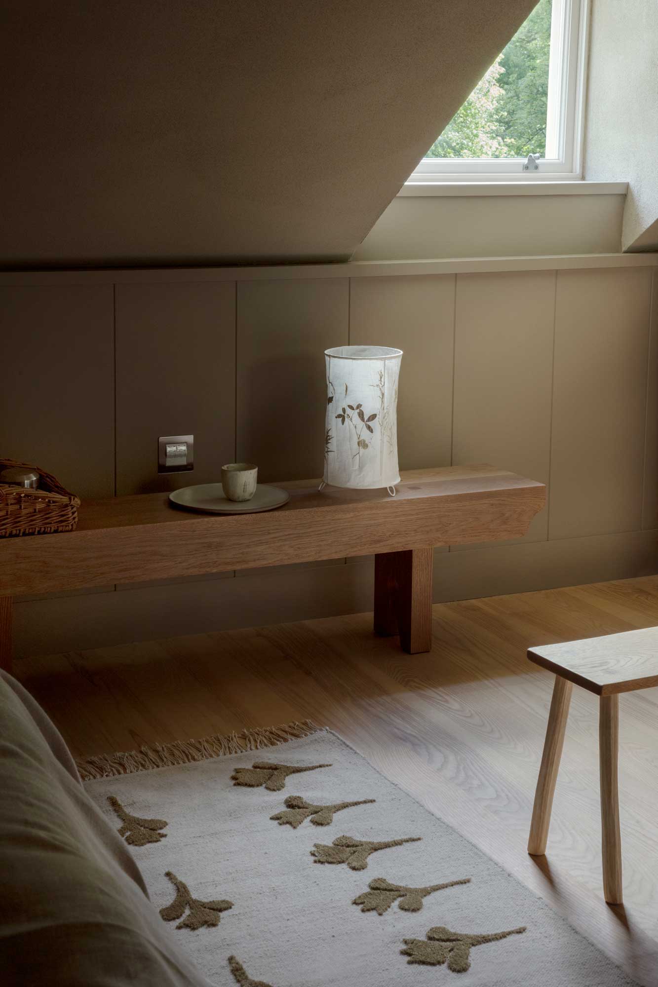 Cozy interior scene with wooden furniture, a vase, and a patterned rug.