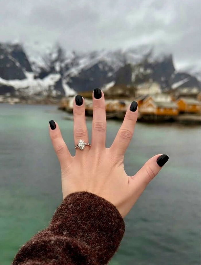 engagement ring in front of town in arctic