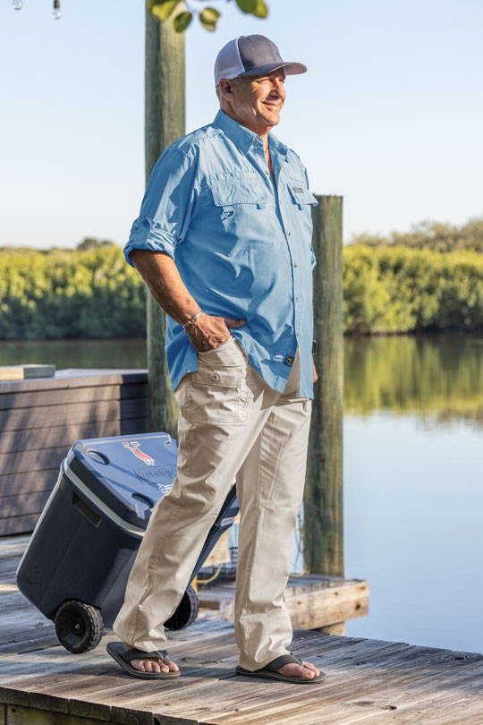 Man walking on dock with cooler wearing Sportif Original Stretch Cargo pants.
