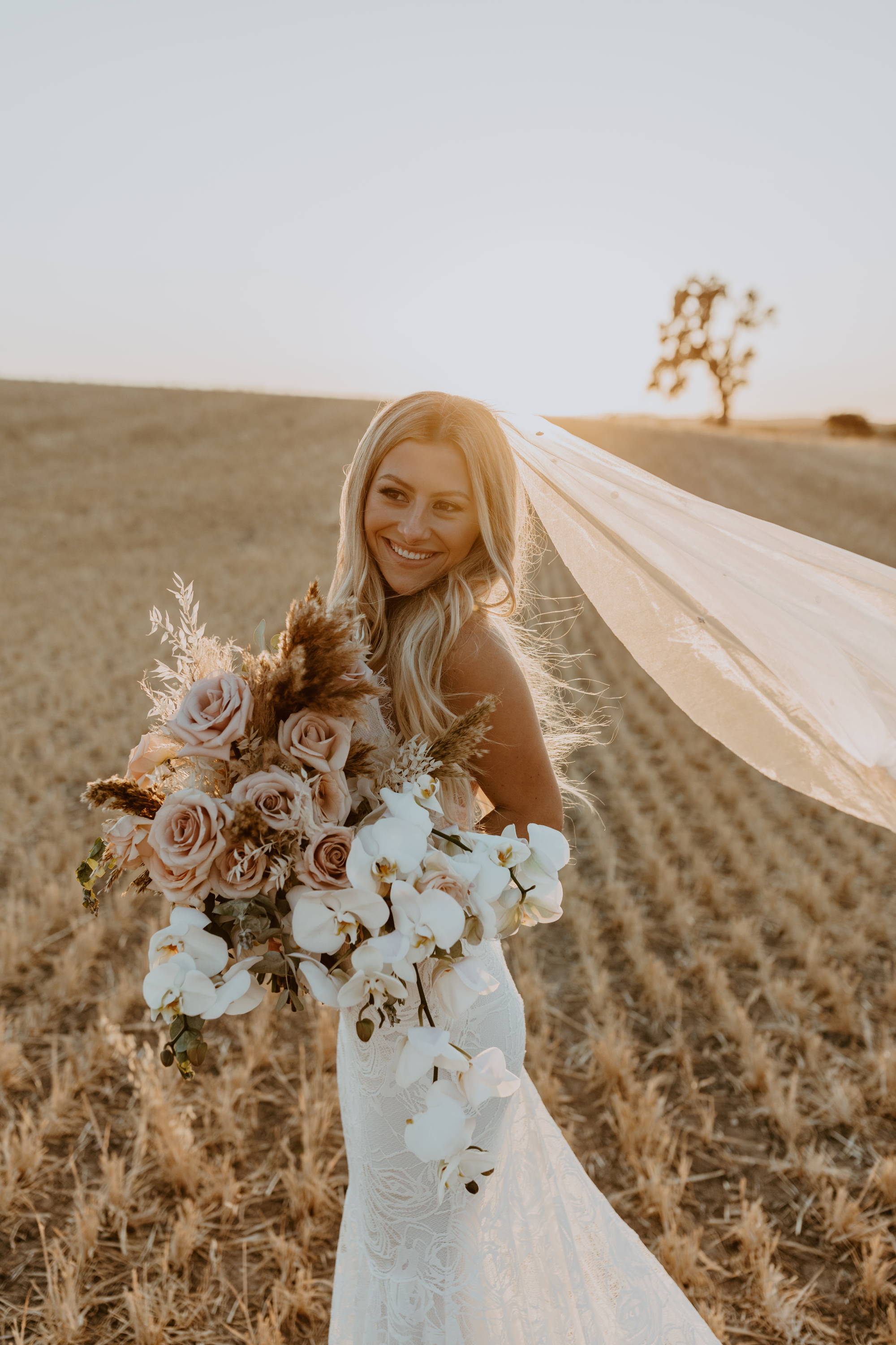 Bride holding white, peach and nude large wedding bouquet
