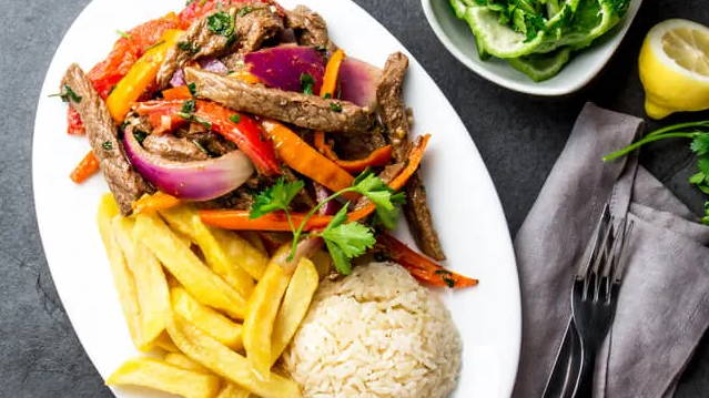 lomo saltado - beef stir fry with peppers and onions with fries and rice