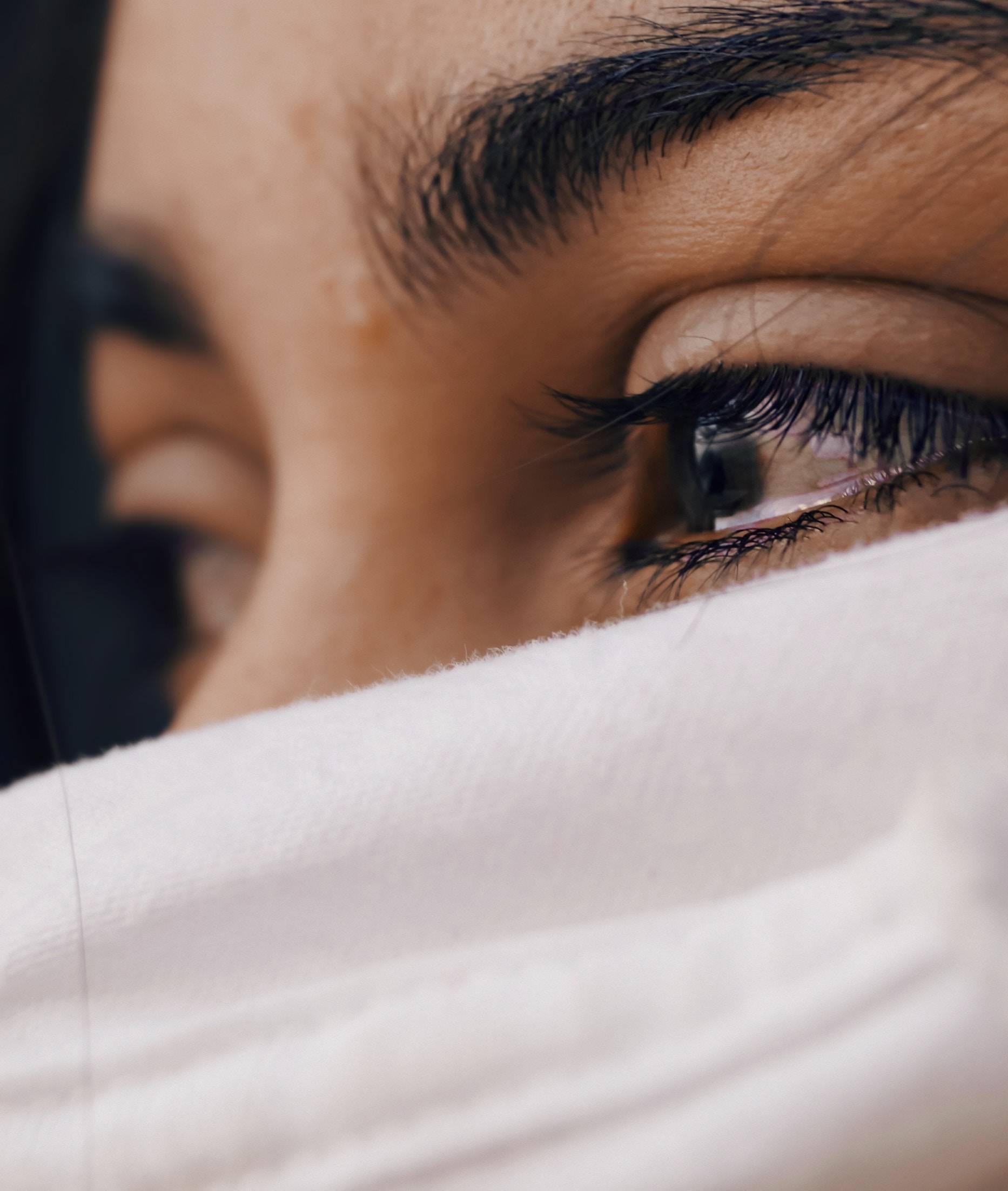 A girl in tears with face covered