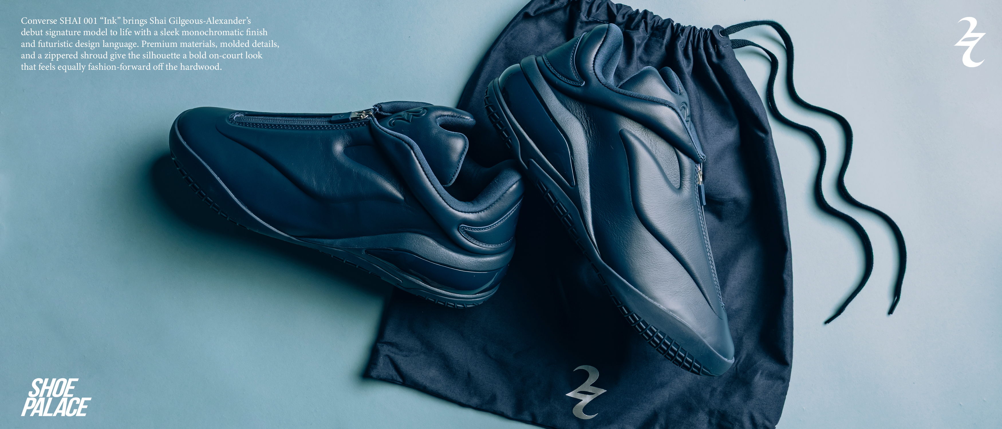 A pair of black sneakers next to black shorts on a light background.