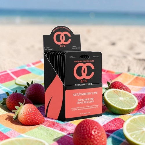 Sunscreen packaging on a beach towel with strawberries and limes.