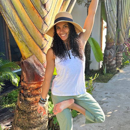 Portrait of Chelsea Ann outside in front of giant palm tree.