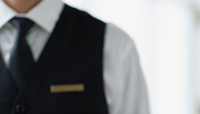 Man wearing a black tie and vest uniform