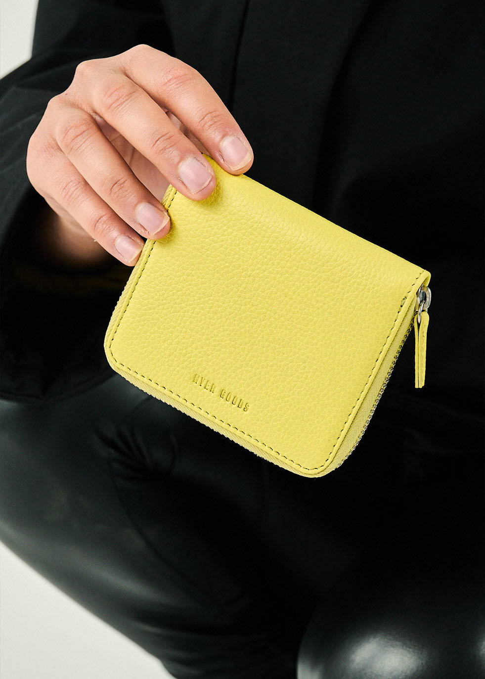 a hand holding a yellow zip wallet