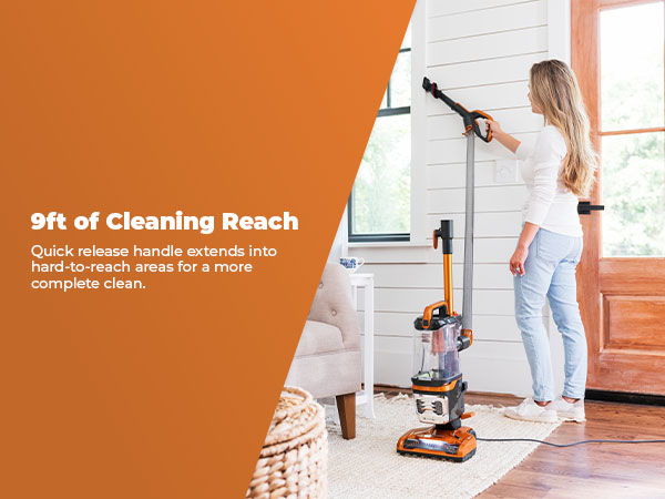 Woman using a vacuum cleaner to clean a wall indoors.