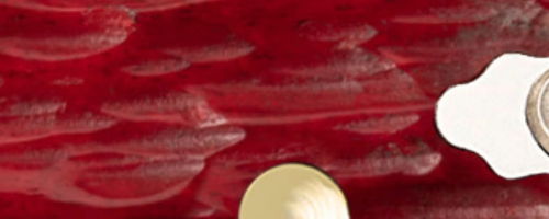 Red textured background with a white and yellow circular object.