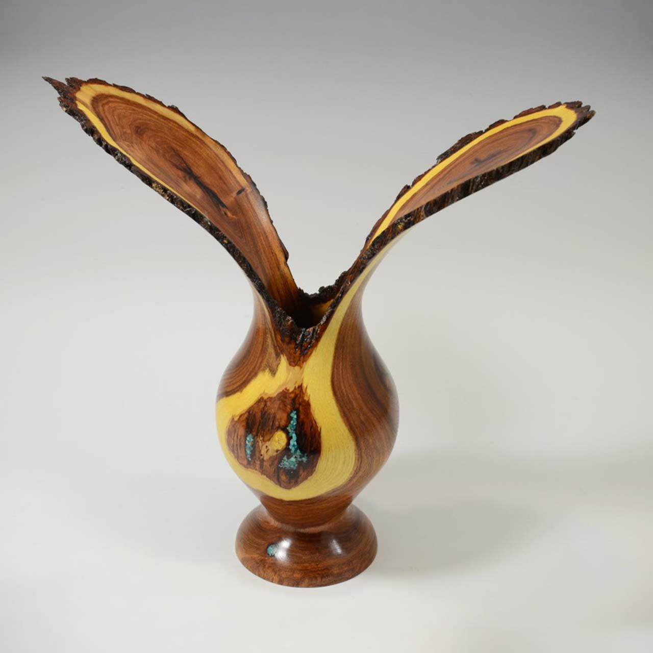 Wooden vase with unique shape and contrasting colors.