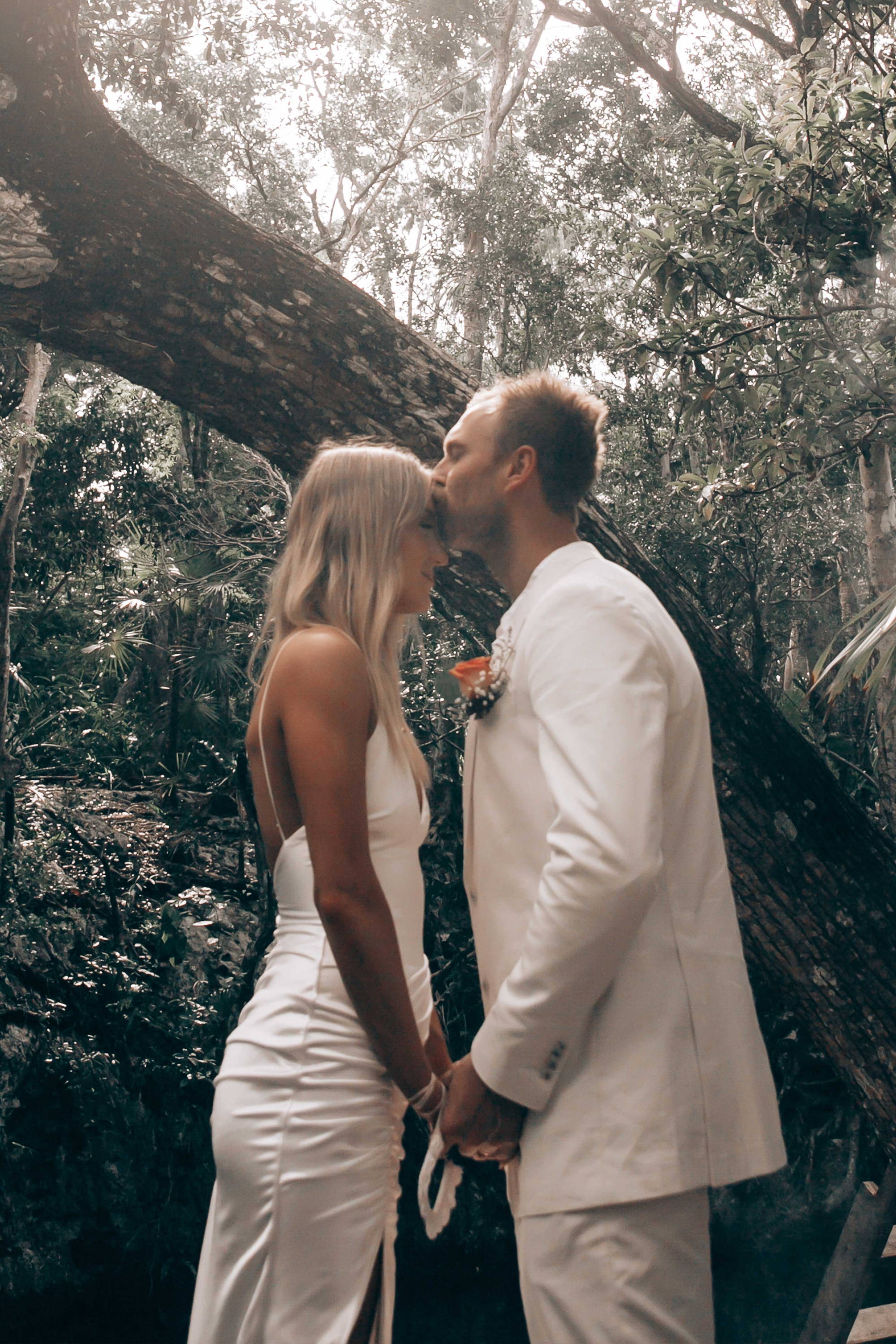 Groom kissing bride on forehead