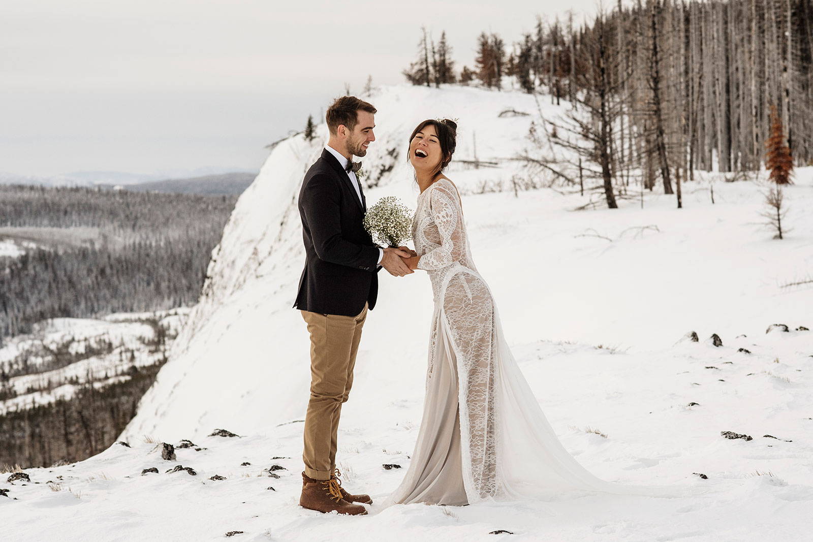 Bride and groom on top of a snowy mountain