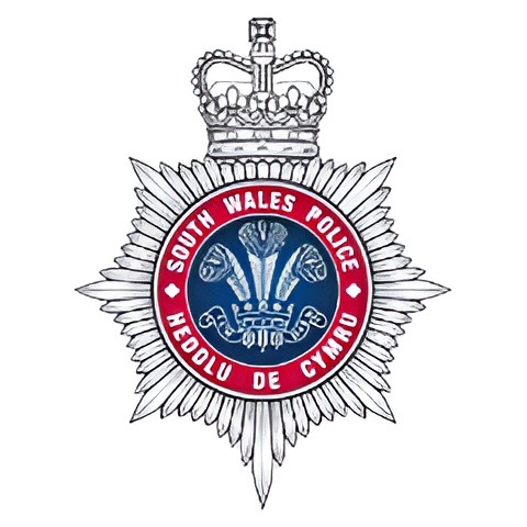 South Wales Police badge with a crown and Welsh symbols.