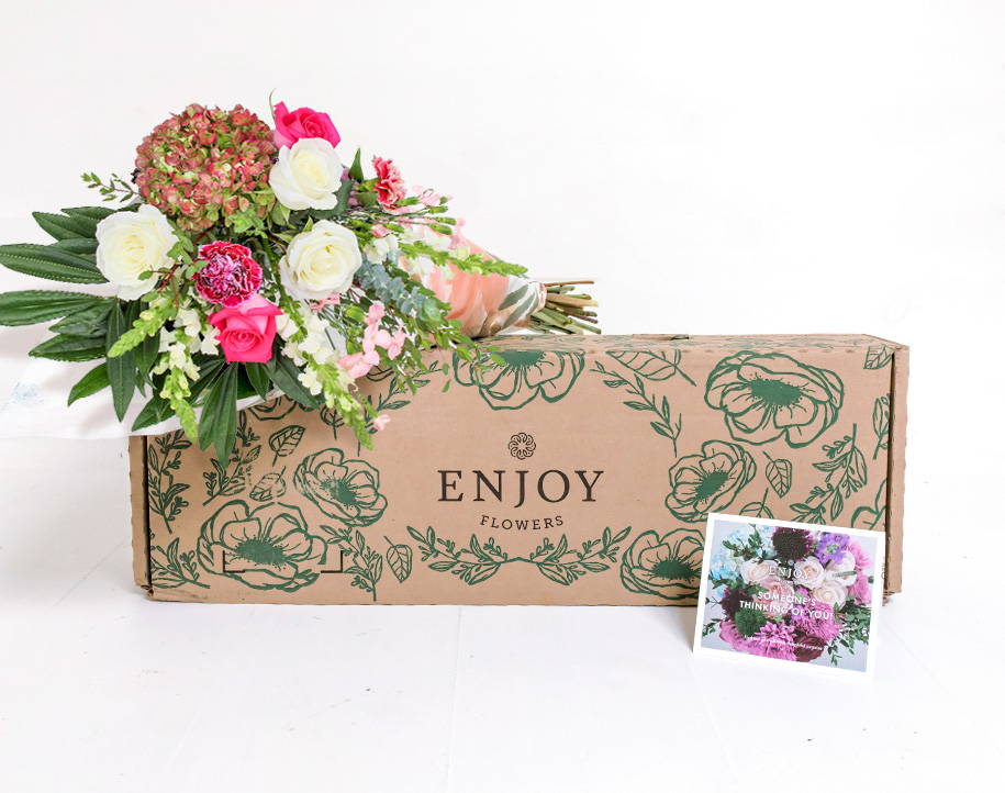 A fresh bouquet of seasonal flowers from the Enjoy Flowers Farm Fresh Collection sits by a box and personalized card. 