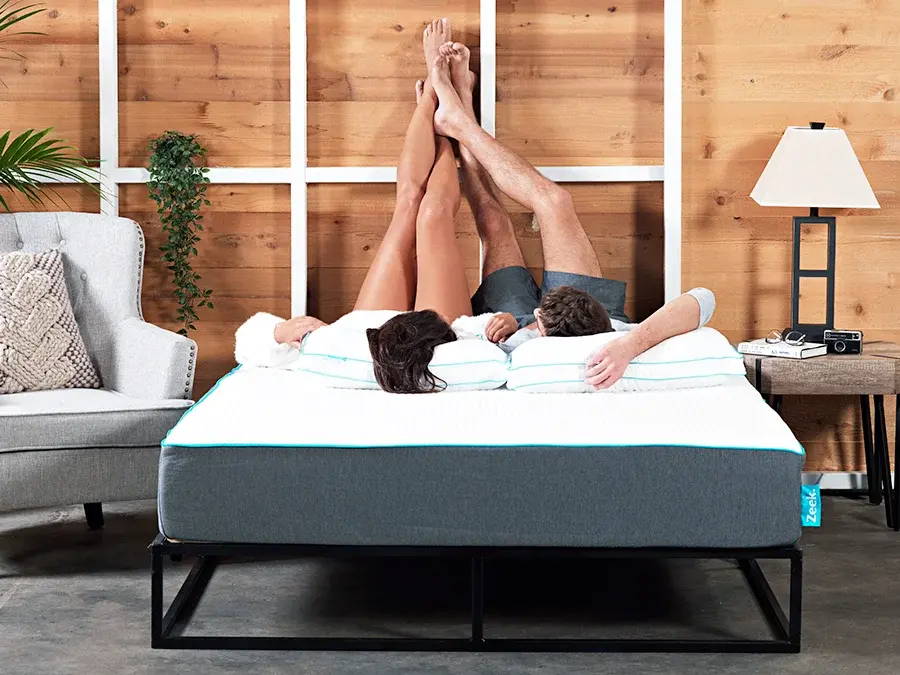 Two people lounging on a Hybrid Mattress from Zeek.com.au, with their feet up.